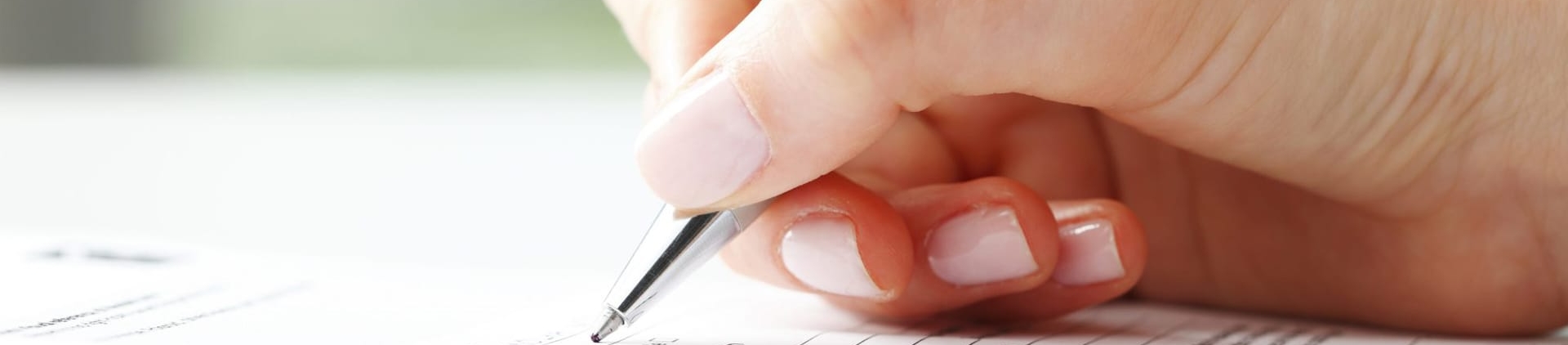 person holding pen to paper