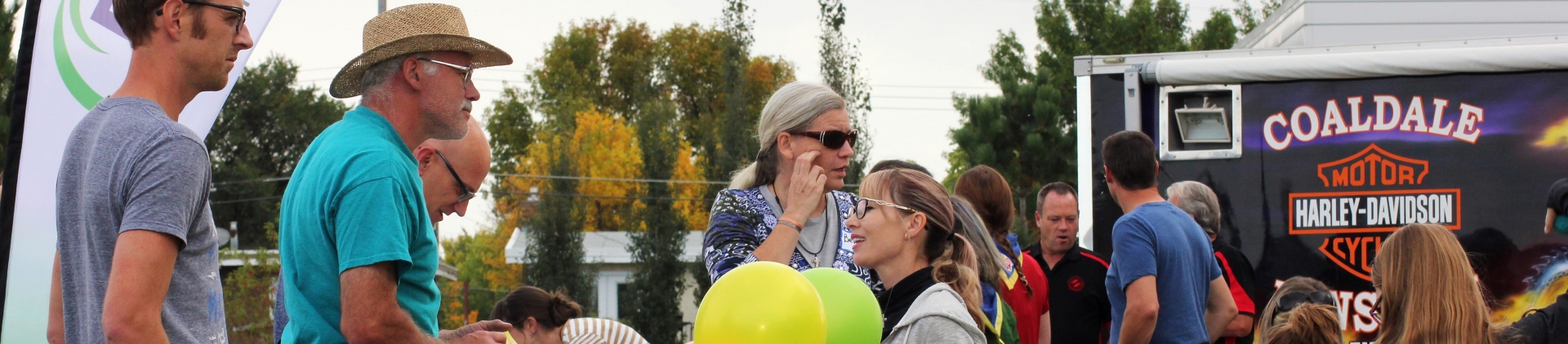 People talking with woman holding balloons.