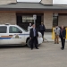 Town Council members standing in front of new RCMP building next to parked police SUV